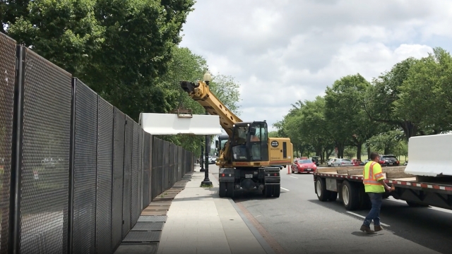 Workers remove concrete barriers near the White House