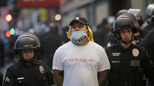 A demonstrator is taken into custody after a curfew went into effect in Los Angeles
