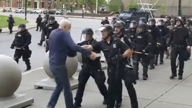 In this image from video provided by WBFO, a Buffalo police officer appears to shove a man who walked up to police.