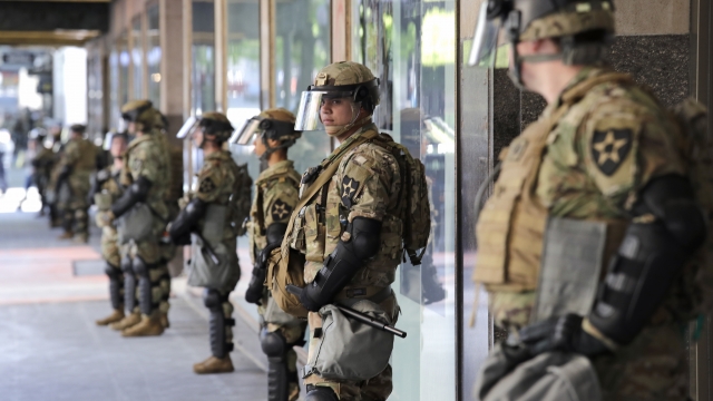 Unarmed Washington National Guard soldiers stand guard outside a previously closed department store.