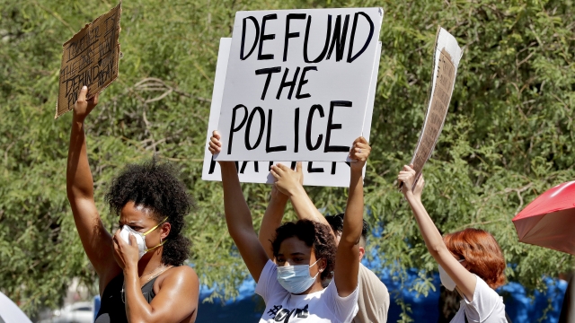 Protester with "Defund The Police" sign