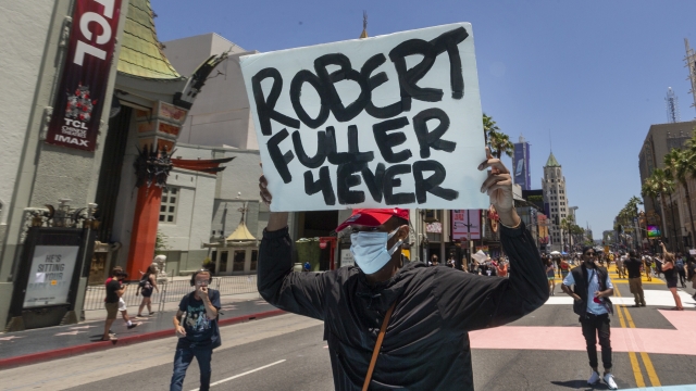 A demonstrator carries a sign reading: "Robert Fuller 4Ever" during an All Black Lives Matter march in Los Angeles.