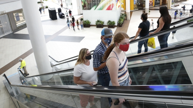 People wearing face masks take an escalator to the second floor of the Arden Fair Mall in Sacramento