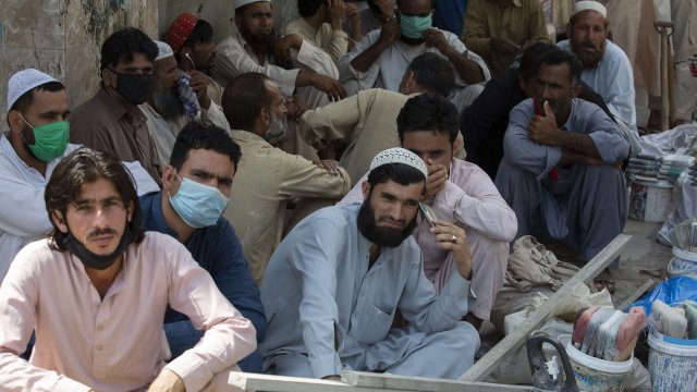 Unmasked daily wage workers wait to be hired by customers in Rawalpindi, Pakistan.
