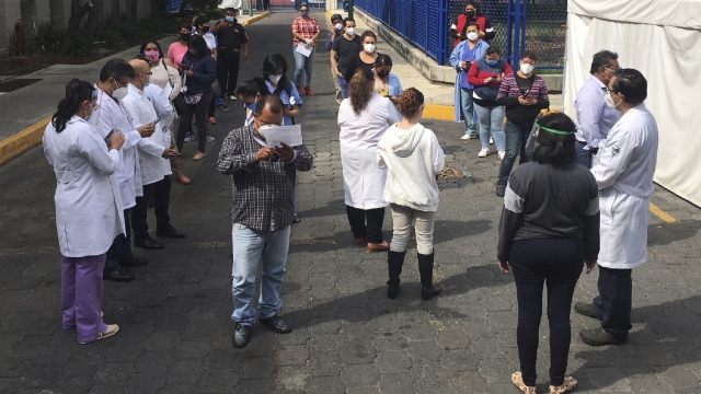 Public Hospital workers in Mexico City wait on street after earthquake on Tuesday.
