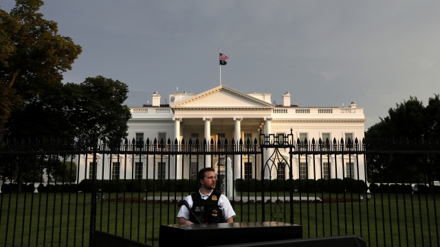 A member of the Secret Service Police stands guard outside the fence of the White House
