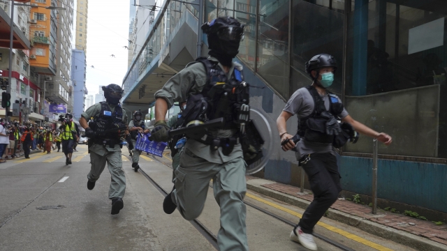 Police chase protesters during the annual handover march in Hong Kong, Wednesday, July. 1, 2020