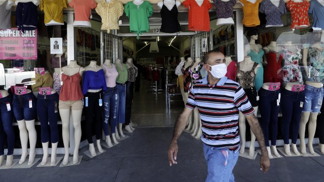 Man in mask passes storefront