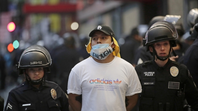 A demonstrator is taken into custody after the city's curfew went into effect in Los Angeles.