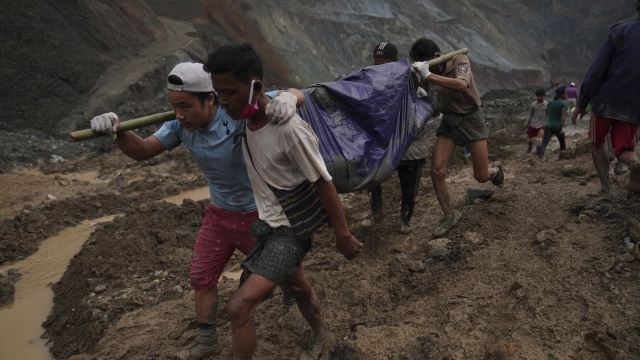 Rescue workers in Myanmar carry a body