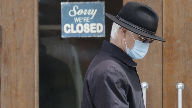 A man walks past a closed business in Shaker Heights, Ohio