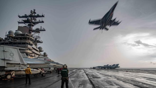 An F/A-18E Super Hornet flies over the flight deck of the Navy’s only forward-deployed aircraft carrier USS Ronald Reagan