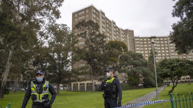 Police guard access to housing commission apartments under lockdown in Melbourne, Australia.