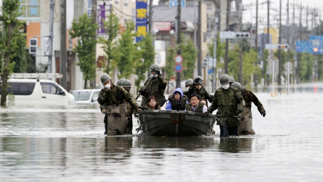 Japanese troops rescue residents from flooding Tuesday in southern Japan city of Omuta.