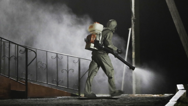 A serviceman of Belarus Ministry of Defence wearing protective gear disinfects a local hospital in the town of Zaslavl