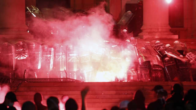 Protesters clash with riot police on the steps of the Serbian parliament during a protest in Belgrade, Serbia, July 11