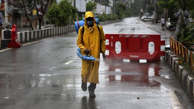 A civic worker sanitizes a deserted road ahead of the lockdown imposed in India.