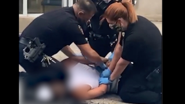 Still from footage of officer kneeling on a man's head.