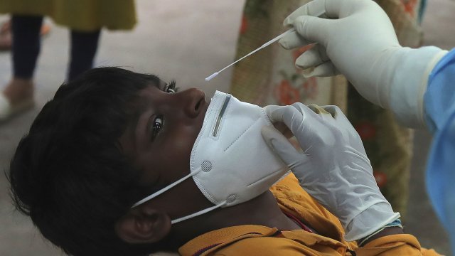 A boy gets his nasal swab sample taken to test for the coronavirus at a government health center in Hyderabad, India