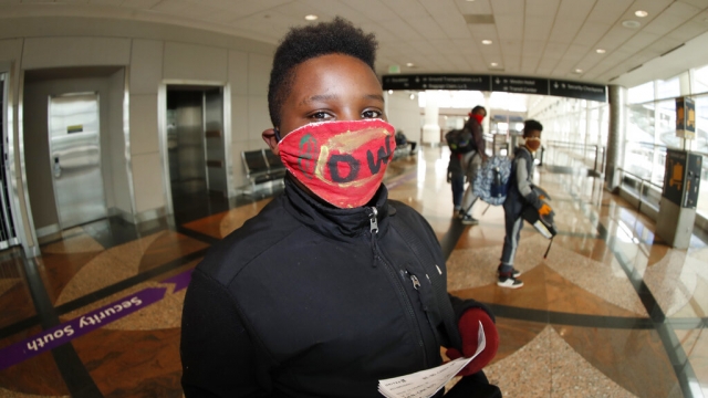 A young traveller wears a face mask