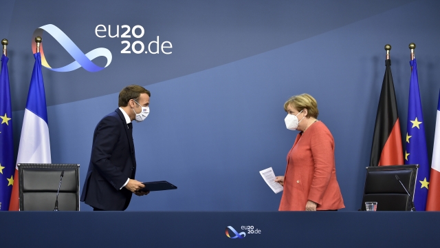 German Chancellor Angela Merkel, right, and French President Emmanuel Macron prepare to address a media conference.