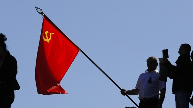 A man holds a Soviet flag