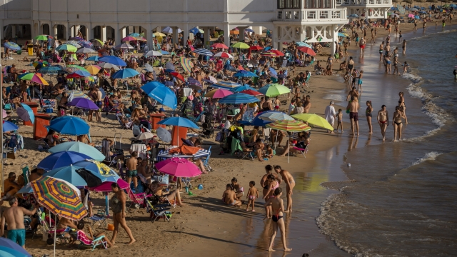 Beachgoers pack into a Spanish waterfront