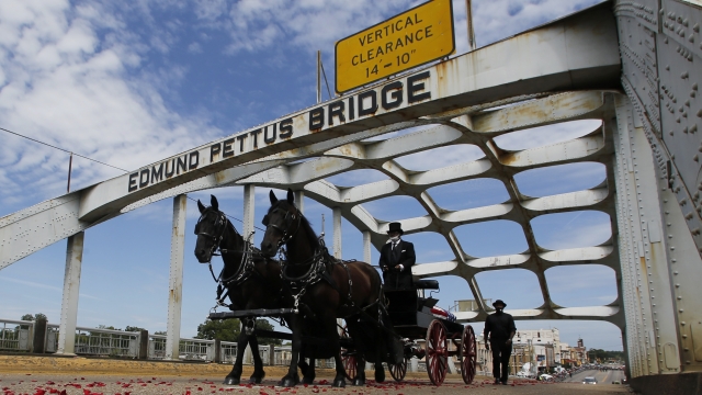 The casket of Rep. John Lewis moves over the Edmund Pettus Bridge by horse drawn carriage during a memorial service for Lewis