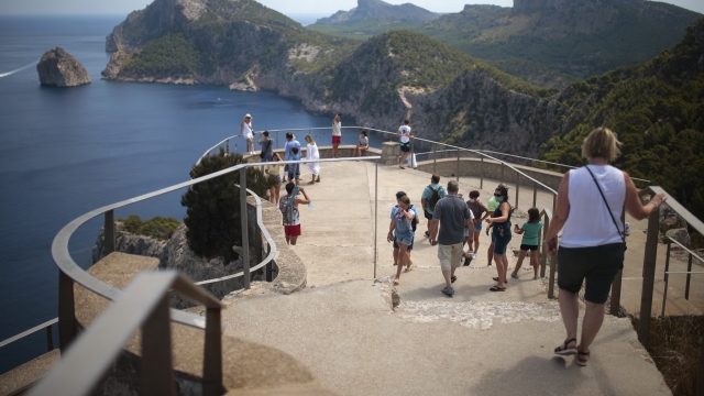 Tourists visit a viewpoint in Pollença, in the Balearic Island of Mallorca, Spain,