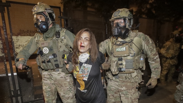 A woman is arrested by federal officers in Portland, Oregon