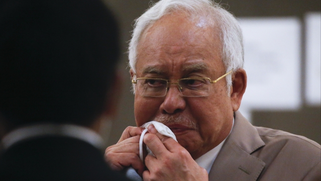 Former Malaysia Prime Minister Najib Razak wipes face in court
