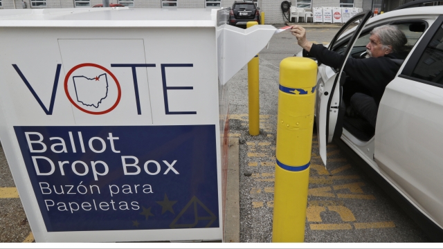 Man puts mail-in ballot in drop box.