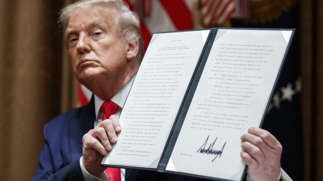 President Trump holds up signed executive order