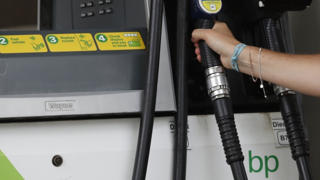 A customer holds of a British Petroleum, BP, petrol pump in west London, Tuesday, Aug. 4, 2020.