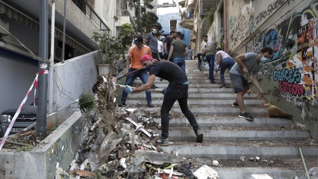 People cleaning up damage in Beirut