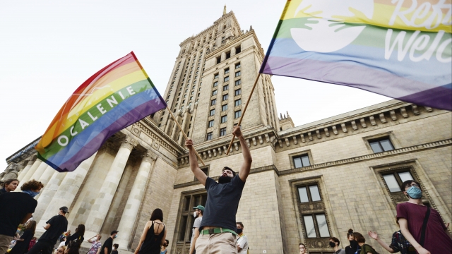 Protester waves two rainbow flags in the middle of Pro-LGBTQ protests