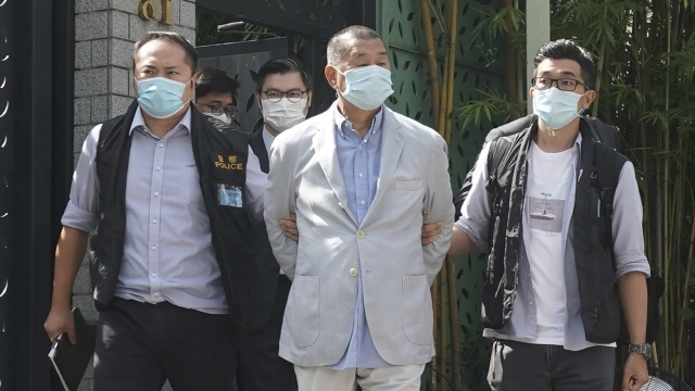 Hong Kong media tycoon Jimmy Lai, center, who founded local newspaper Apple Daily, is arrested by police officers