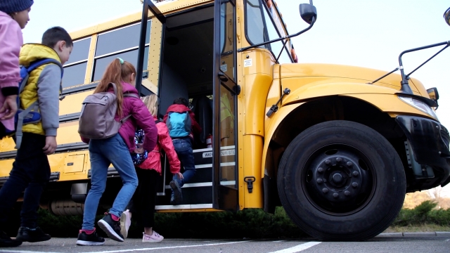Children boarding a school bus.