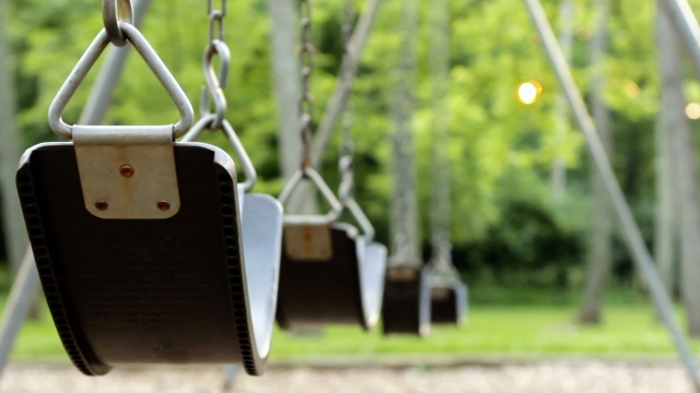 Several swings on a playground.