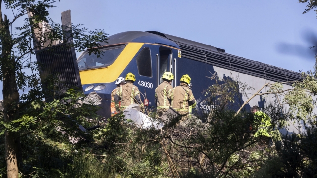 Emergency services attend the scene of a derailed train in Stonehaven, Scotland, Wednesday Aug. 12, 2020.