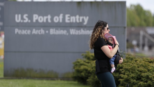 Woman and baby walk through State Park border crossing
