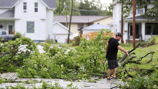Iowa man clears tree debris in front of his home