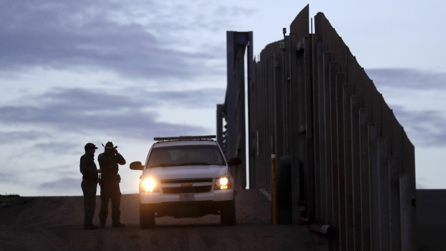United States Border Patrol agents stand by a vehicle near one of the border walls separating Tijuana, Mexico and San Diego