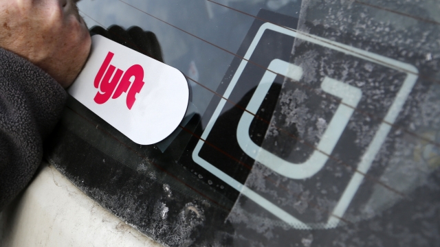 A Lyft logo and an Uber logo