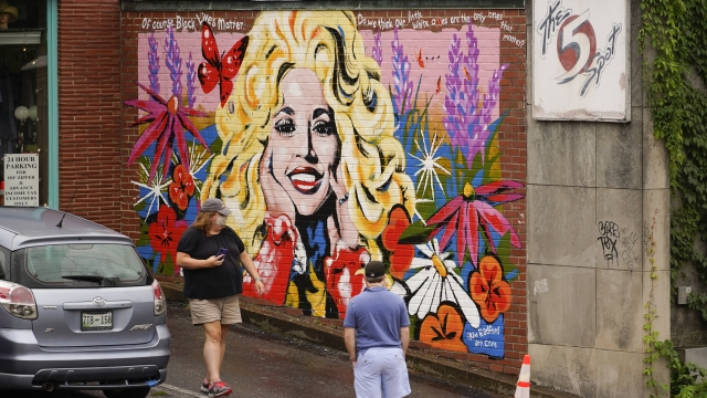 People look at a mural of Dolly Parton outside The 5 Spot, a music club in Nashville, Tenn., Friday, Aug. 21, 2020