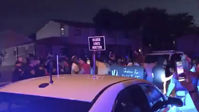 Protesters gather at the sight where a Black man was shot by police