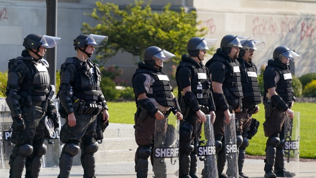 Police in riot gear stand outside the Kenosha County Court House following police shooting Sunday