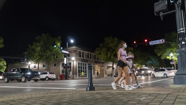 Students wander among heavy car traffic on The Strip, the University of Alabama's bar scene.