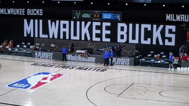 Officials stand by empty court Wednesday after Milwaukee Bucks refuse to take the floor in protest over police shooting.