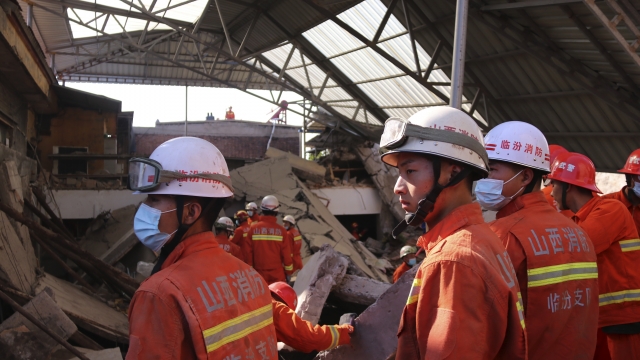 Rescuers search for victims in the aftermath of the collapse of a two-story restaurant in in northern China's Shanxi province